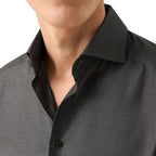 Close-up of a man wearing a dark charcoal gray textured button-down shirt with a classic collar. Eton Shirt available at Sakks Menswear in Southampton.