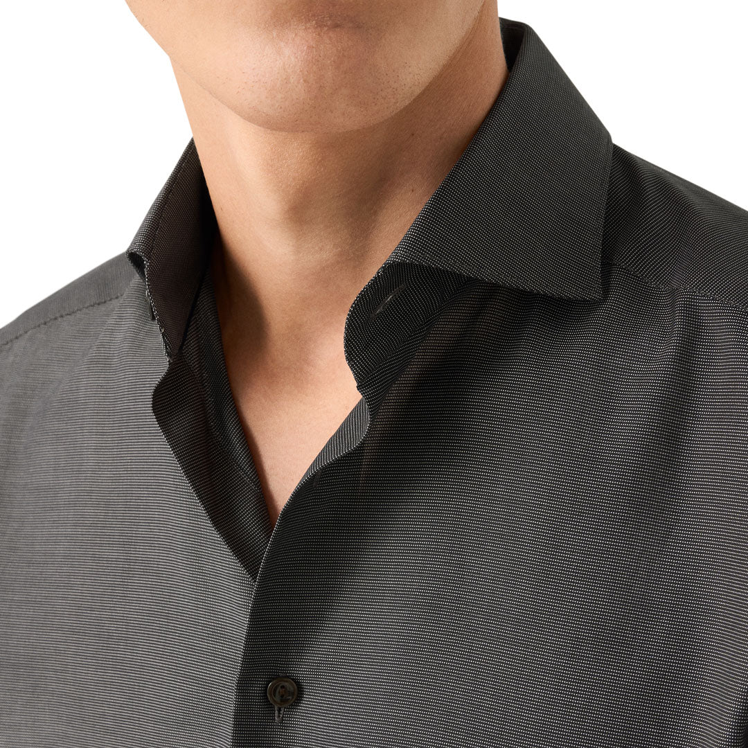 Close-up of a man wearing a dark charcoal gray textured button-down shirt with a classic collar. Eton Shirt available at Sakks Menswear in Southampton.