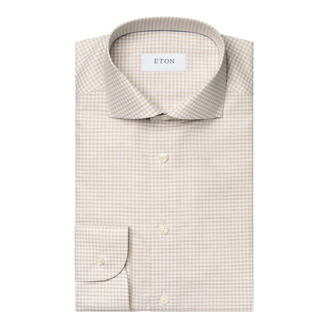 A folded ETON dress shirt in a fine beige and white gingham check pattern, featuring a classic collar, button-down front, and a single-button cuff. Eton Shirt available at Sakks Menswear in Southampton.