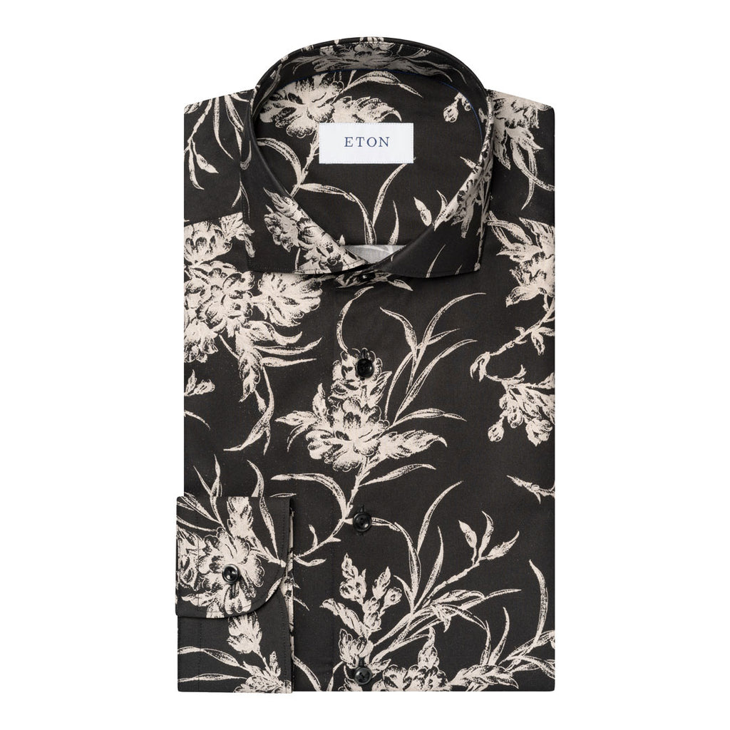 A folded long-sleeve button-up shirt by ETON, featuring a black base with a detailed beige and white floral print. Eton Shirt available at Sakks Menswear in Southampton.