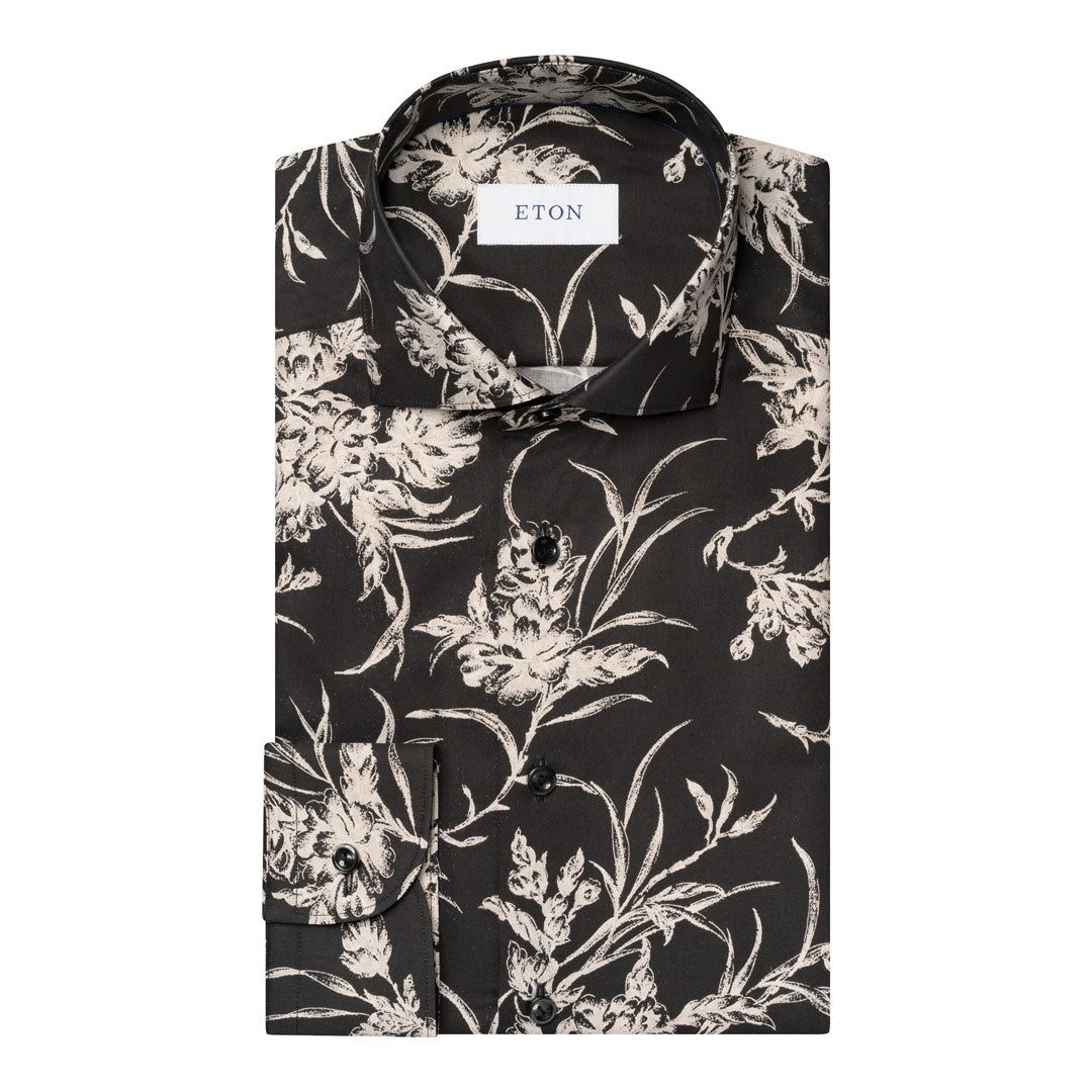 A folded long-sleeve button-up shirt by ETON, featuring a black base with a detailed beige and white floral print. Eton Shirt available at Sakks Menswear in Southampton.