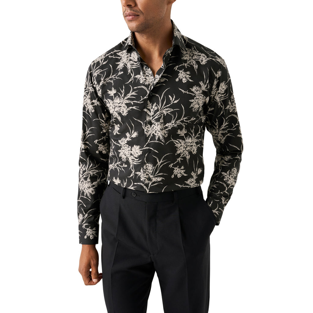 A man wearing a black long-sleeve button-up shirt with a beige floral pattern, paired with black trousers, shown against a plain white background. Eton Shirt available at Sakks Menswear in Southampton.