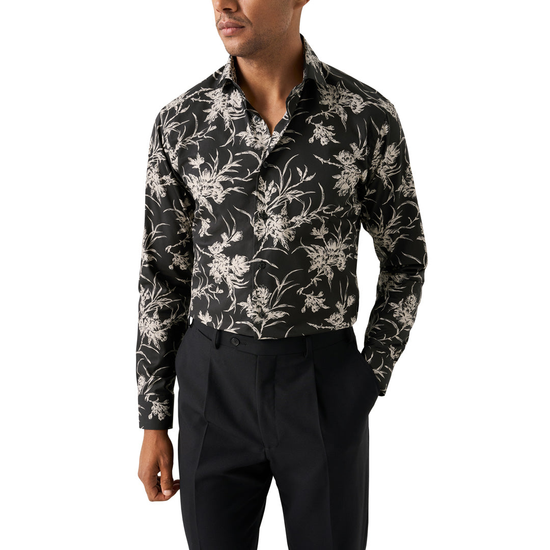 A man wearing a black long-sleeve button-up shirt with a beige floral pattern, paired with black trousers, shown against a plain white background. Eton Shirt available at Sakks Menswear in Southampton.