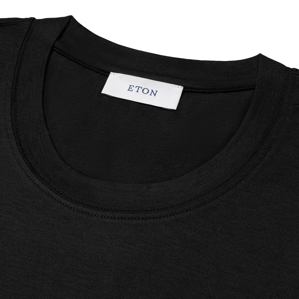 Close-up of a black crew-neck t-shirt showing the inner neck label which reads 'ETON'.Eton T-Shirt available at Sakks Menswear in Southampton.
