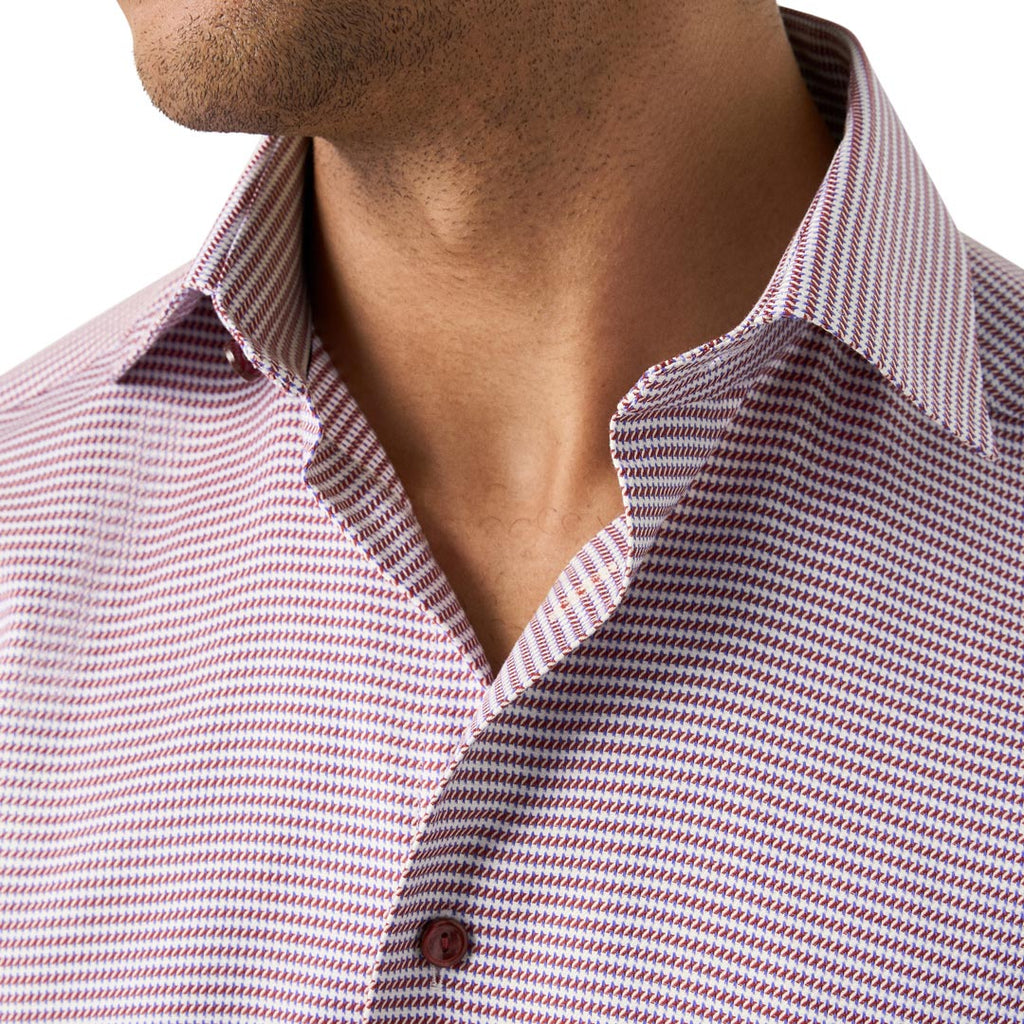 Close-up of a man wearing a collared button-up shirt with a fine red and white micro-pattern. Eton Shirt available at Sakks Menswear in Southampton.
