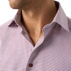 Close-up of a man wearing a collared button-up shirt with a fine red and white micro-pattern. Eton Shirt available at Sakks Menswear in Southampton.