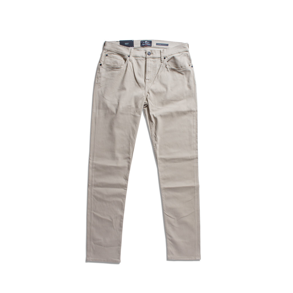A pair of light beige slim-fit jeans shown flat against a solid white background. 7 For All Mankind Chinos available at Sakks Menswear in Southampton.