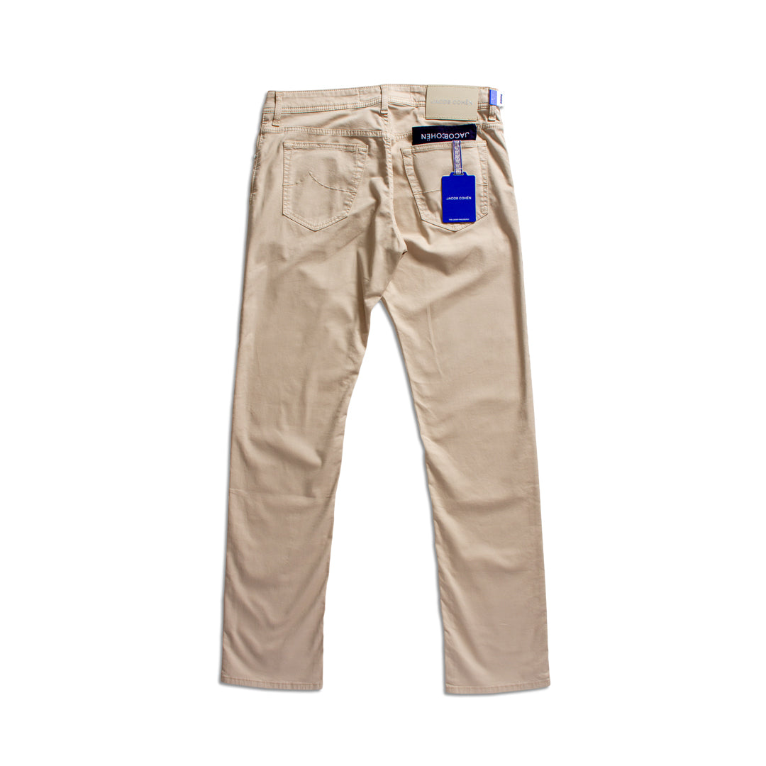 A pair of beige chino pants shown from the back, featuring a blue hangtag and a black brand label on the back waistband, set against a plain white background. Jacob Cohën Chinos available at Sakks Menswear in Southampton.