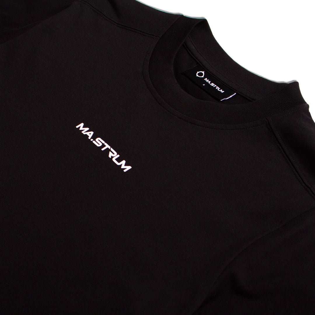 Close-up of a black crewneck sweatshirt with the brand name 'MA.STRUM' printed in white on the left chest and on the inner neck label. MA.Strum T-Shirt available at Sakks Menswear in Southampton.