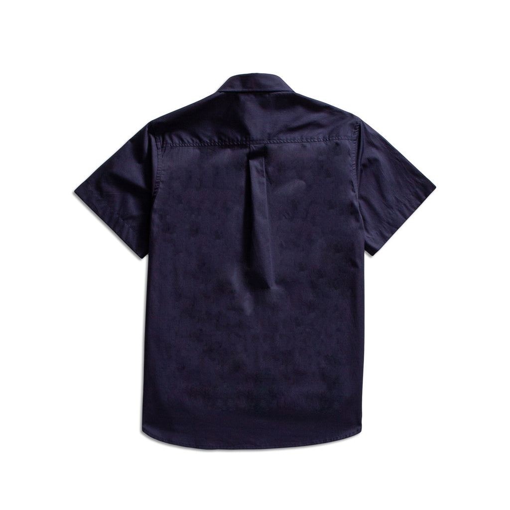 A dark navy blue short-sleeve button-up shirt shown from the back, featuring a subtle tonal textured pattern and a single button closure at the collar, photographed against a solid white background. MA.Strum Short Sleeve Shirt available at Sakks Menswear in Southampton.