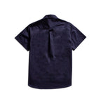 A dark navy blue short-sleeve button-up shirt shown from the back, featuring a subtle tonal textured pattern and a single button closure at the collar, photographed against a solid white background. MA.Strum Short Sleeve Shirt available at Sakks Menswear in Southampton.