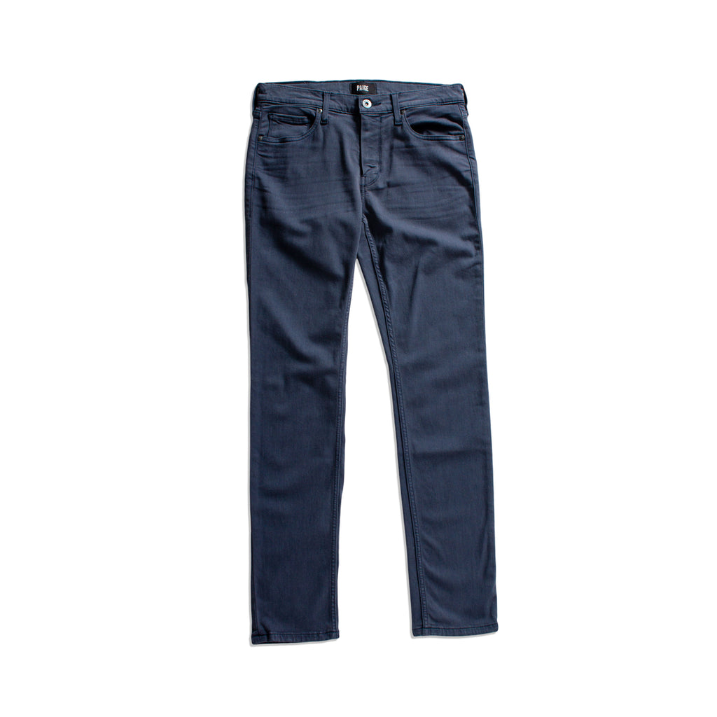 Blue jeans with a slight distressed look on a white background. PAIGE Jeans available at Sakks Menswear in Southampton.