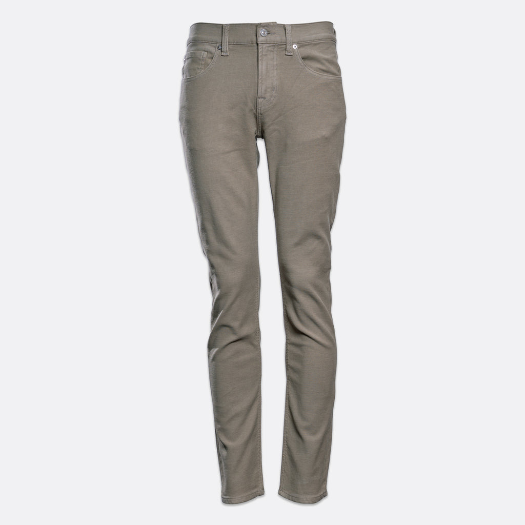 A pair of slim-fit jeans in a muted taupe-gray color, shown on a clean, light gray background. 7 For All Mankind. Sakks Menswear Southampton.