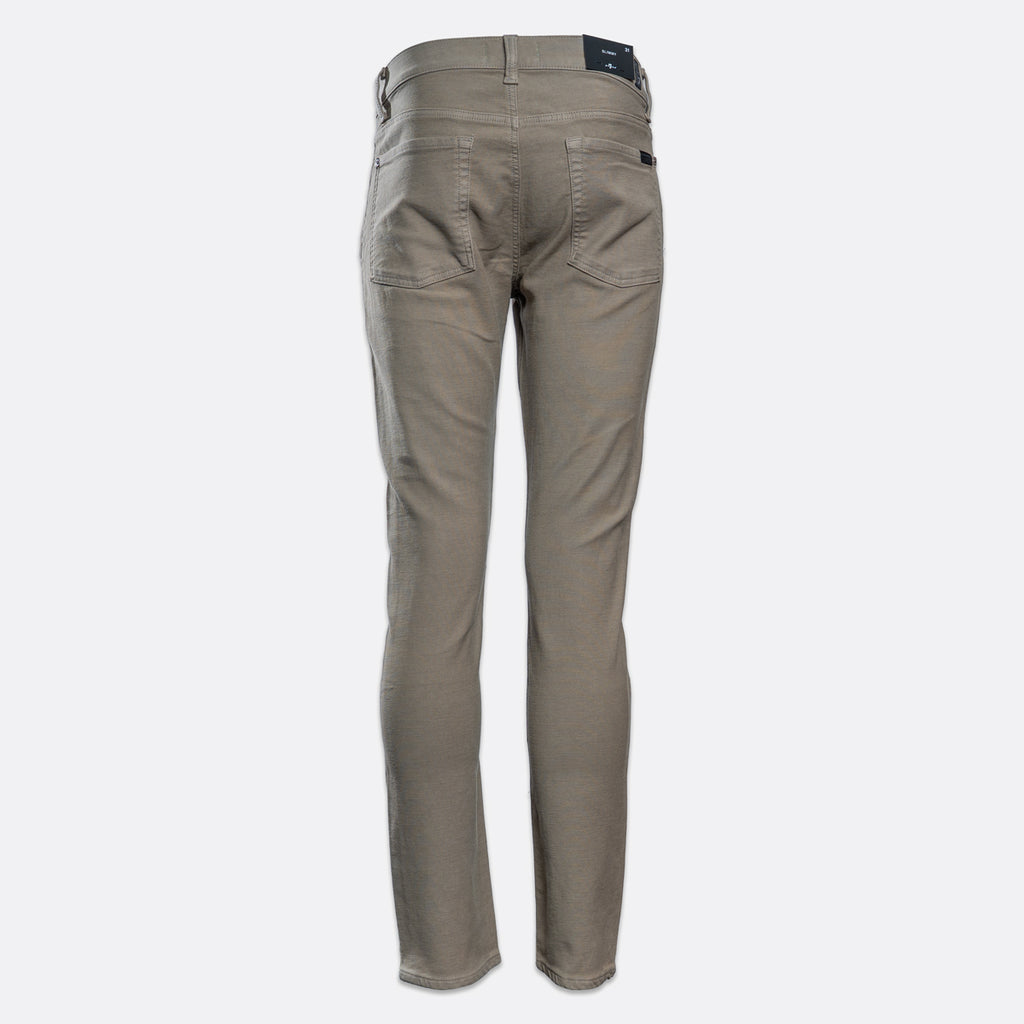 A pair of slim-fit jeans in a muted taupe-gray color, shown on a clean, light gray background. 7 For All Mankind. Sakks Menswear Southampton.