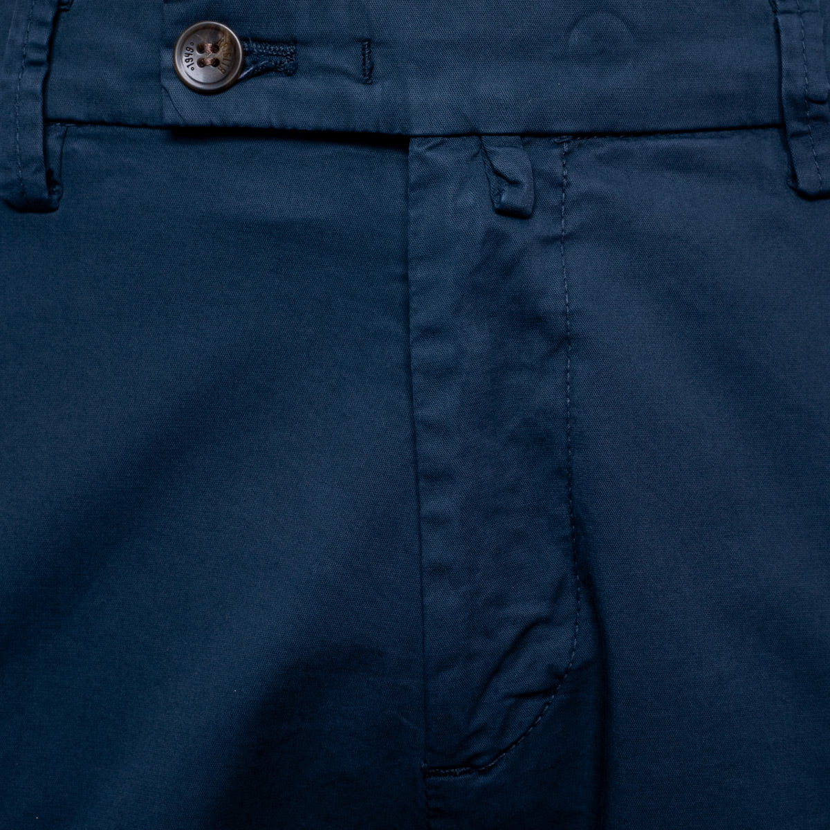 Close-up of dark navy blue trousers showing the waistband, button closure, belt loops, and front seam. Briglia Bermuda Shorts. Sakks Menswear Southampton.
