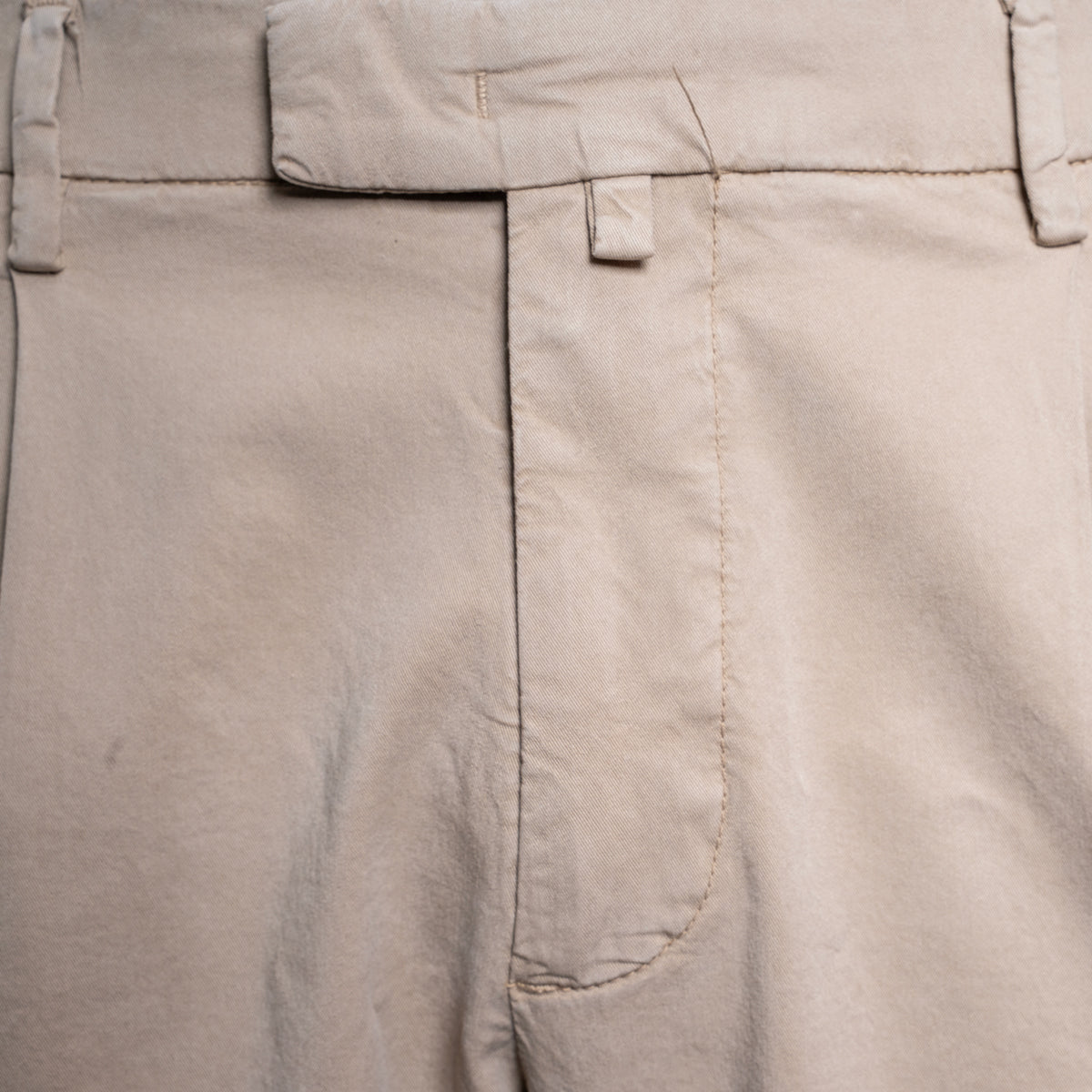 Close-up of light beige trousers showing the waistband, belt loops, front fly, and a side welt pocket. Briglia Trousers. Sakks Menswear Southampton.