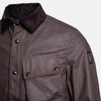 Close-up of a brown waxed cotton jacket with a dark corduroy collar, snap-button front, and a Brixton logo patch on the sleeve. Belstaff Jacket. Sakks Menswear Southampton.