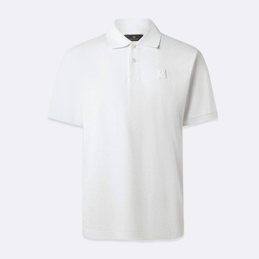 A white short-sleeve polo shirt with a small white embroidered logo on the left chest, displayed on a clean, light gray background. Belstaff Polo. Sakks Menswear Southampton.