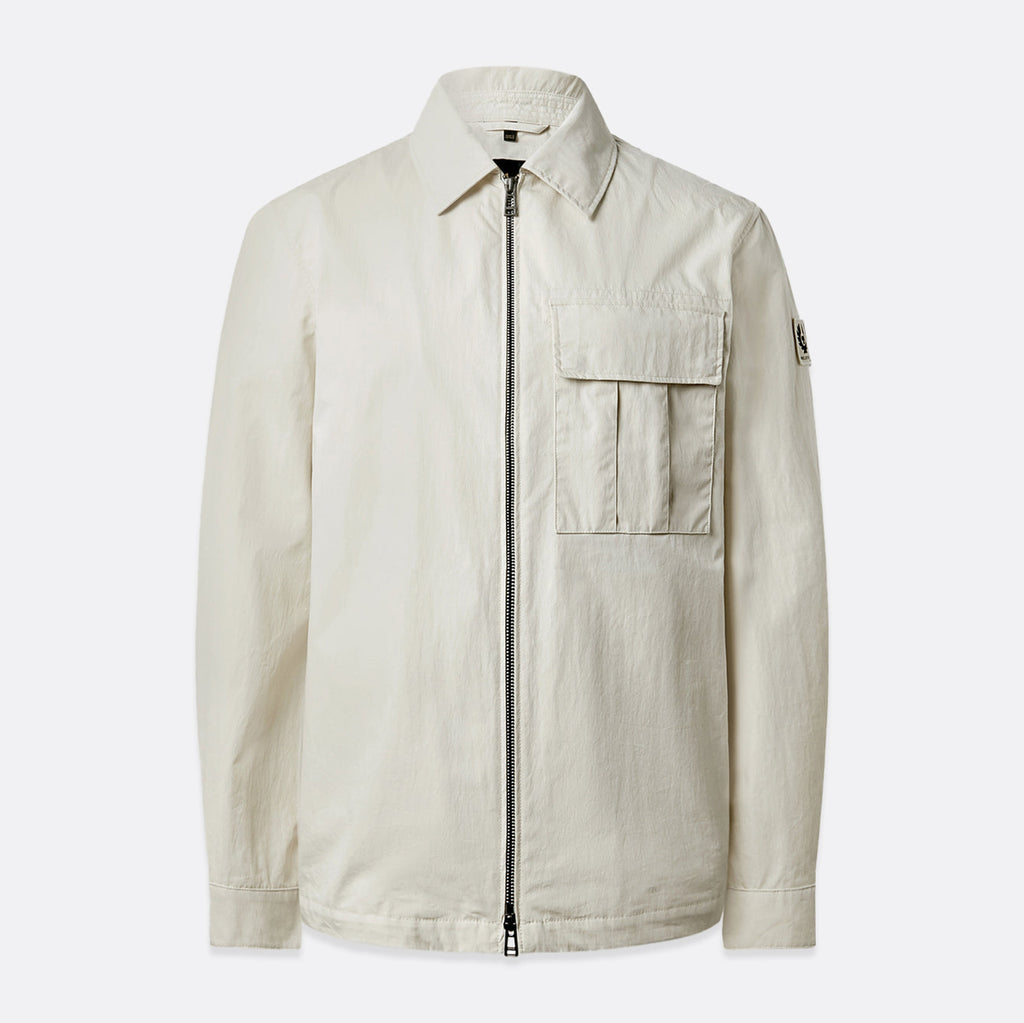 A light beige utility jacket with a front zipper, a pointed collar, a chest flap pocket, and a small sleeve patch, shown against a light gray background. Belstaff Jacket. Sakks Menswear Southampton.