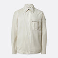 A light beige utility jacket with a front zipper, a pointed collar, a chest flap pocket, and a small sleeve patch, shown against a light gray background. Belstaff Jacket. Sakks Menswear Southampton.