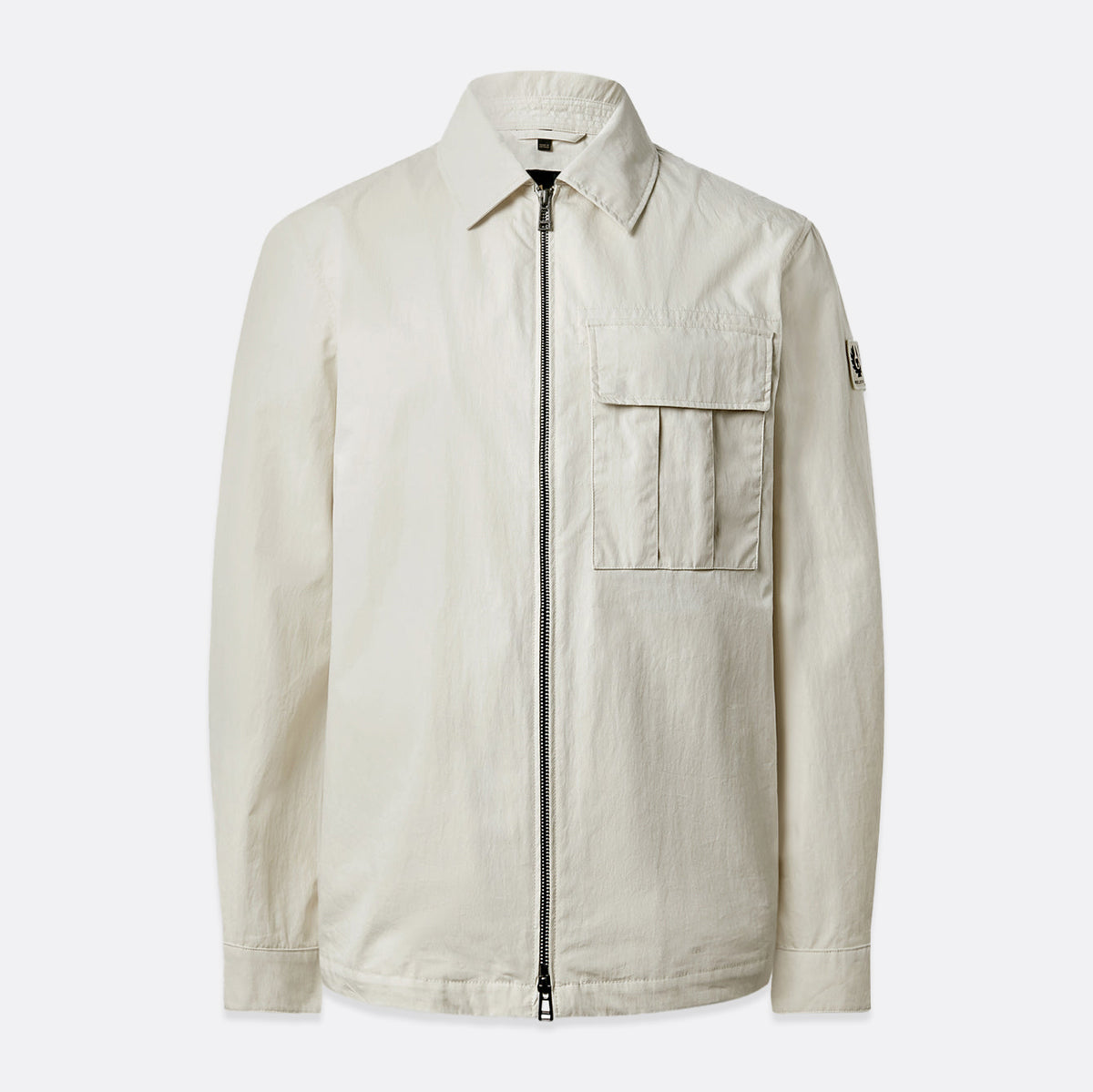 A light beige utility jacket with a front zipper, a pointed collar, a chest flap pocket, and a small sleeve patch, shown against a light gray background. Belstaff Jacket. Sakks Menswear Southampton.