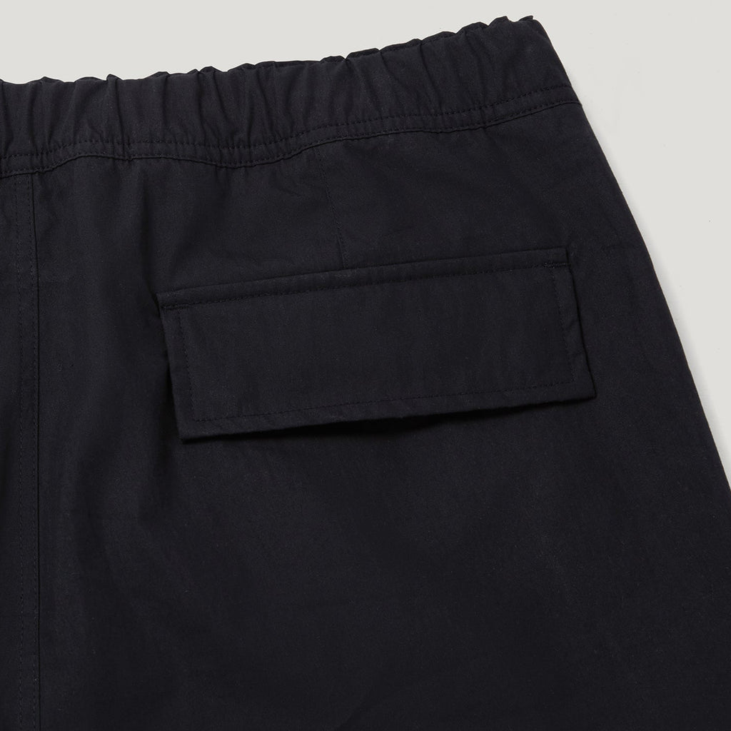 Close-up of black elastic-waist pants showing a side pocket and waistband detail against a light gray background. Belstaff Cargo Pants. Sakks Menswear Southampton.