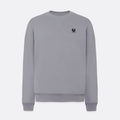 A light gray crewneck sweatshirt with a small black embroidered logo on the left chest, displayed on a clean light gray background. Belstaff Sweatshirt. Sakks Menswear Southampton.