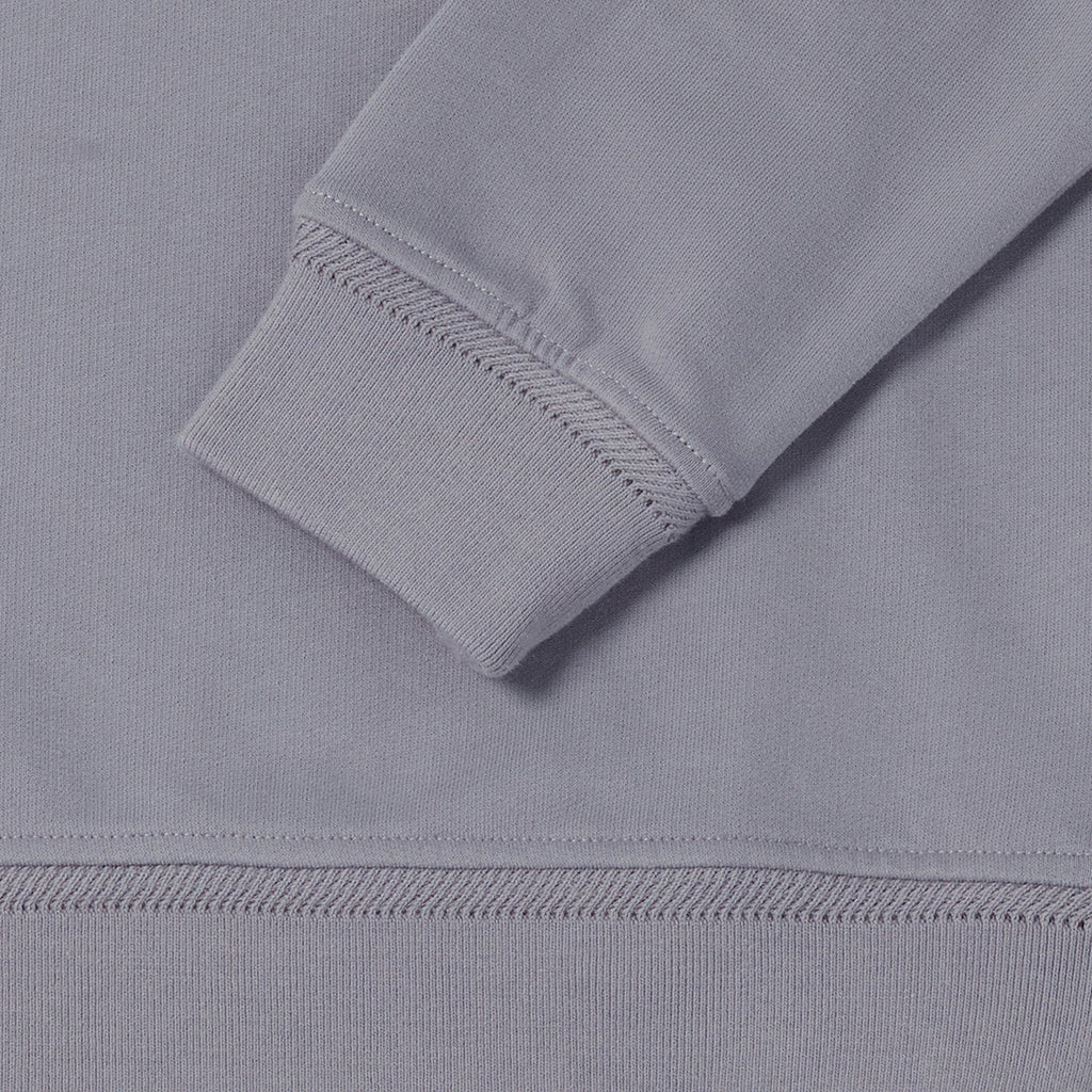 Close-up detail of a light gray ribbed knit garment, showing the cuff of a long sleeve with diagonal stitching and the hem of the fabric. Belstaff Sweatshirt. Sakks Menswear Southampton.