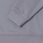 Close-up detail of a light gray ribbed knit garment, showing the cuff of a long sleeve with diagonal stitching and the hem of the fabric. Belstaff Sweatshirt. Sakks Menswear Southampton.