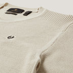 Close-up of a cream-colored ribbed knit sweater with a small embroidered logo on the chest and a black neck label. Belstaff Sweatshirt. Sakks Menswear Southampton.