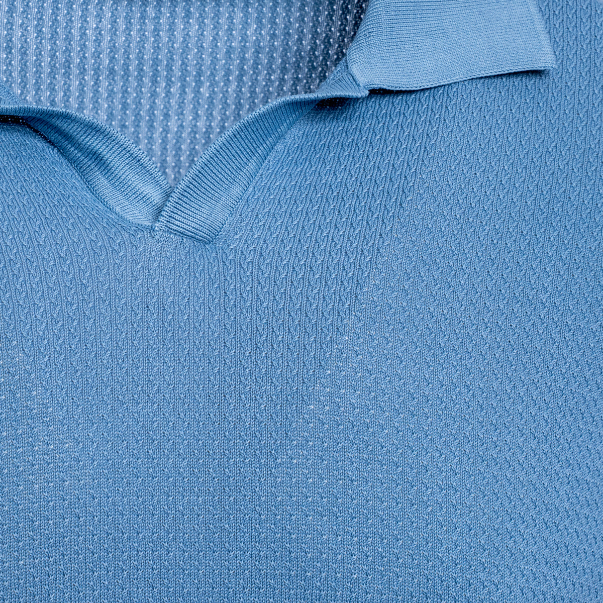 Close-up of a light blue knit polo shirt showing the textured fabric and collar detail. Circolo 1901 Polo Shirt. Sakks Menswear Southampton.