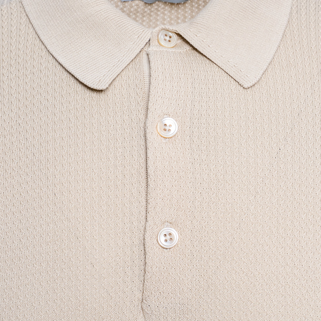 Close-up of a beige knit polo shirt showing the collar, three white buttons, and a fine textured fabric. Circolo 1901 Polo. Sakks Menswear Southampton.
