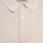 Close-up of a beige knit polo shirt showing the collar, three white buttons, and a fine textured fabric. Circolo 1901 Polo. Sakks Menswear Southampton.