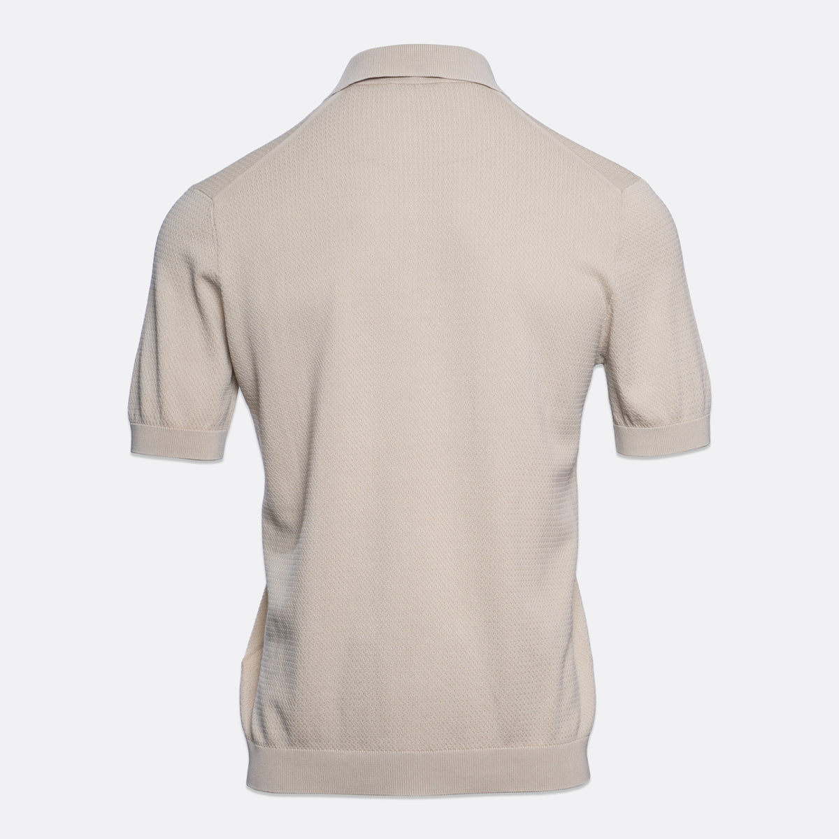 A light beige short-sleeve polo shirt shown from the back, featuring a textured knit fabric and a classic collar, set against a plain light grey background. Circolo 1901 Polo. Sakks Menswear Southampton.