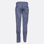 Blue denim trousers shown from the back, featuring a slim fit and two buttoned flap pockets, set against a plain light gray background. Circolo 1901 Trousers. Sakks Menswear Southampton.