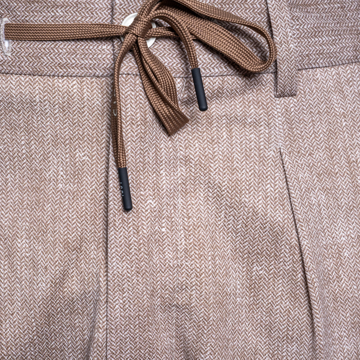 Close-up of brown herringbone-patterned trousers with a matching drawstring waist and black tip accents. Circolo 1901 Trousers. Sakks Menswear Southampton.