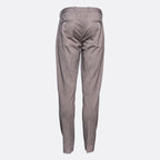 A pair of slim-fit trousers shown from the back, featuring a subtle textured pattern in a muted grayish-brown tone, set against a plain light gray background. Circolo 1901 Trousers. Sakks Menswear Southampton.