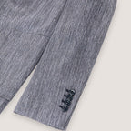 Close-up of a textured gray herringbone blazer sleeve showing three dark buttons on the cuff against a light beige background. Circolo 1901 Blazer. Sakks Menswear Southampton.