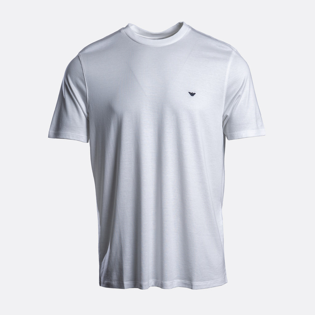 A white short-sleeve crewneck t-shirt with a small dark embroidered logo on the left chest, displayed on a light gray background. Emporio Armani T-Shirt. Sakks Menswear Southampton.