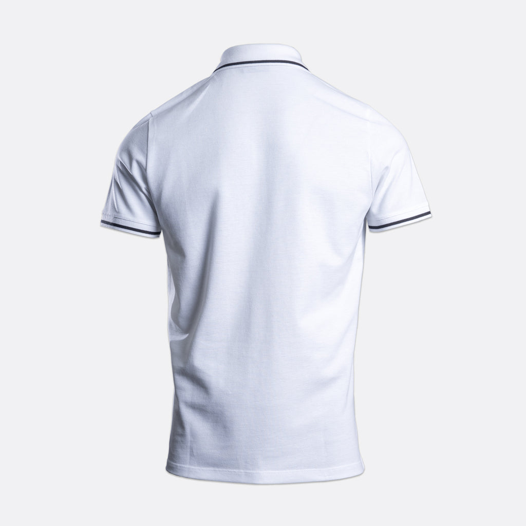 White short-sleeve polo shirt shown from the back, featuring thin dark navy piping trim along the collar and sleeve cuffs, set against a light gray background. Emporio Armani Polo. Sakks Menswear Southampton.