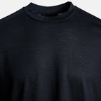 Close-up of a dark charcoal gray knit mock neck sweater with a subtle tonal embroidered logo on the left chest, set against a light gray background. Emporio Armani T-Shirt. Sakks Menswear Southampton.