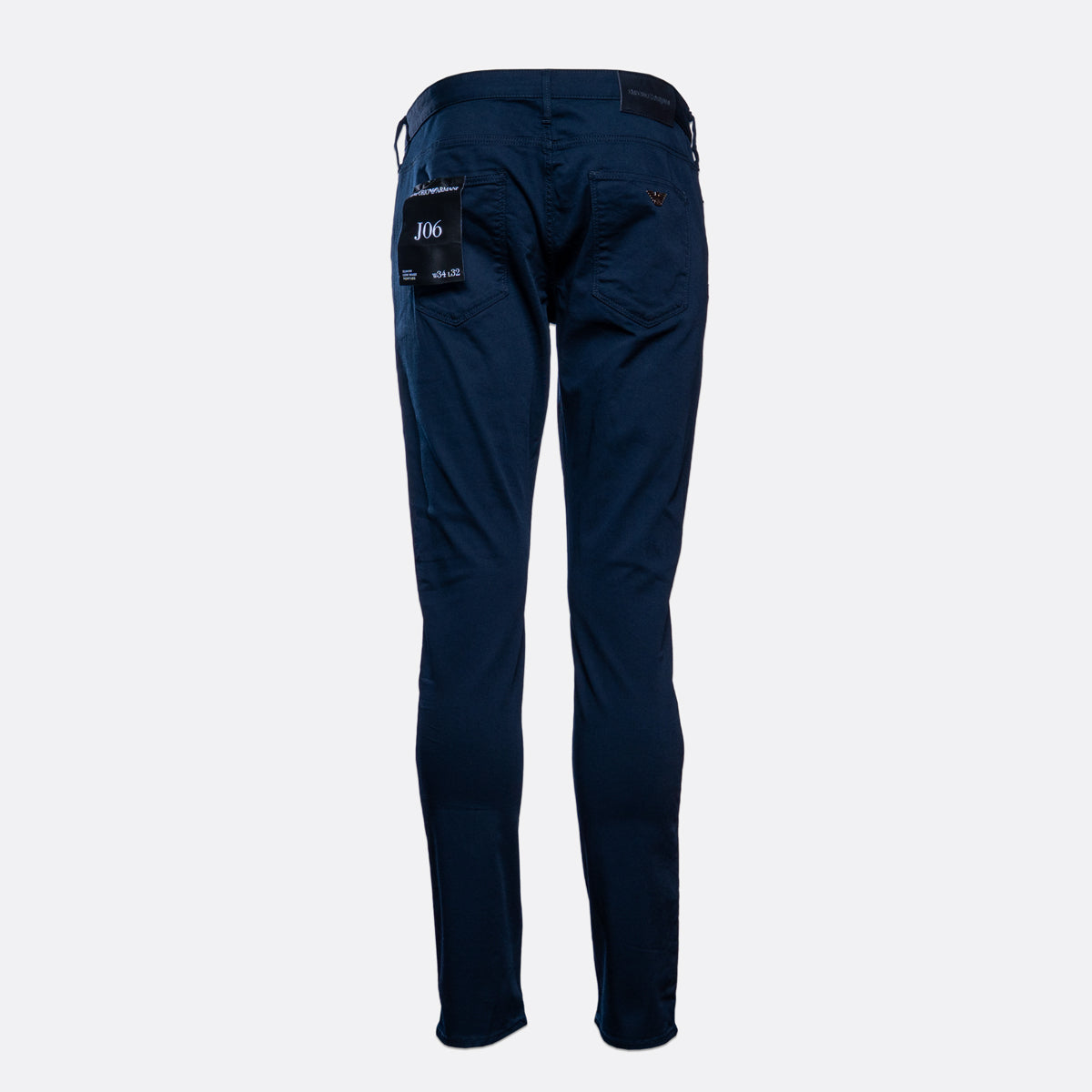 A pair of dark navy blue slim-fit pants shown from the back, featuring a black brand patch on the right pocket, set against a plain light gray background. Emporio Armani Chinos. Sakks Menswear Southampton.