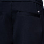 Close-up of dark navy pants showing the back pocket with a small silver embroidered logo on the upper right side. Emporio Armani Sweat Pants. Sakks Menswear Southampton.