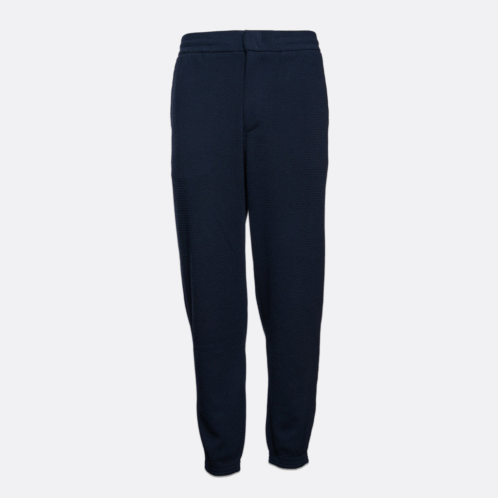A pair of dark navy blue textured jogger pants shown flat against a light gray background. Emporio Armani Sweat Pants. Sakks Menswear Southampton.