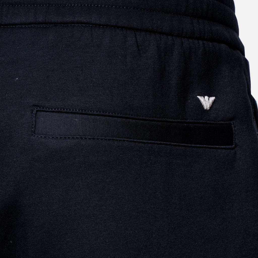 Close-up of dark navy athletic shorts showing the back pocket with a black fabric tab and a small silver embroidered logo. Emporio Armani Shorts. Sakk Menswear Southampton.