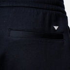 Close-up of dark navy athletic shorts showing the back pocket with a black fabric tab and a small silver embroidered logo. Emporio Armani Shorts. Sakk Menswear Southampton.