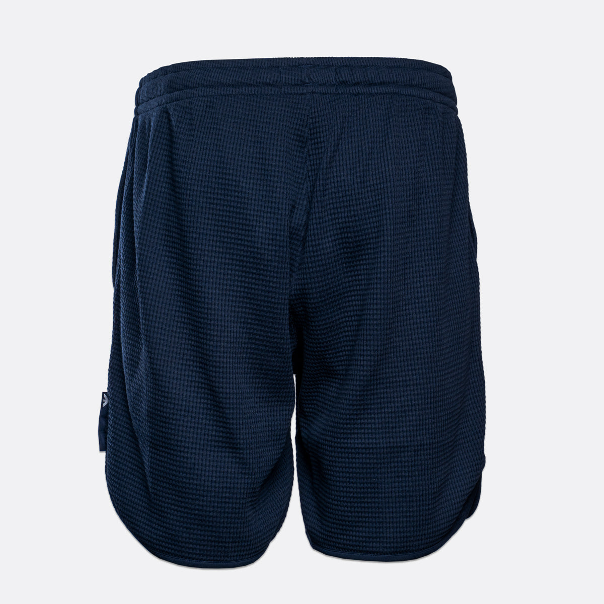 A pair of navy blue athletic shorts with a textured waffle knit fabric, shown from the back against a light gray background. Emporio Armani Shorts. Sakks Menswear Southampton.