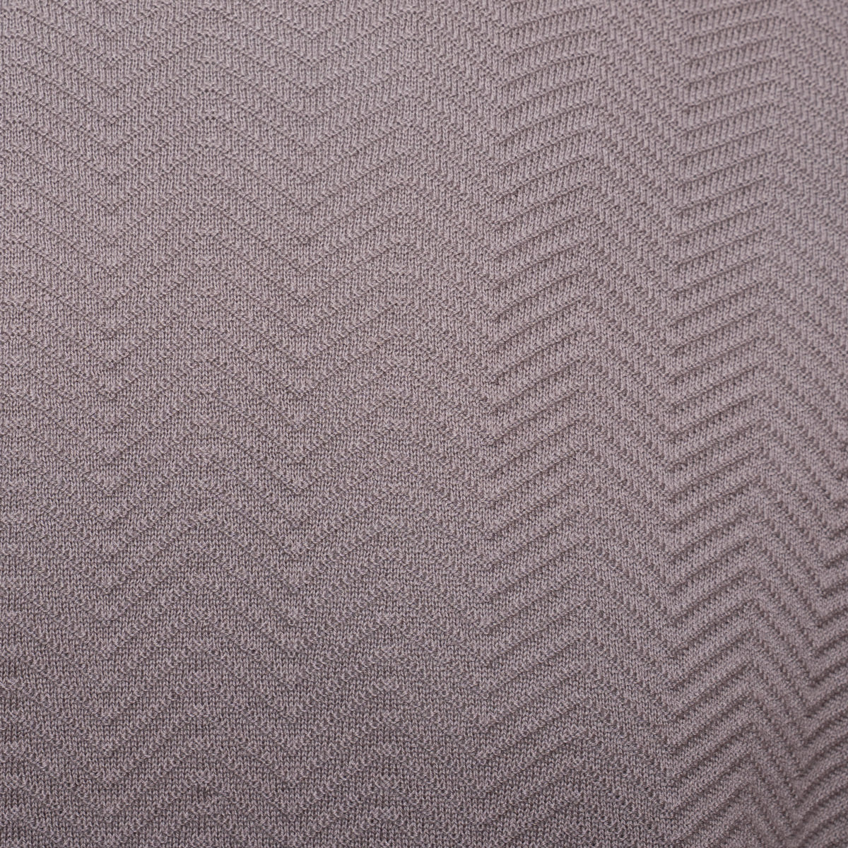 A close-up of a textured fabric with a woven herringbone pattern in a muted taupe-gray color. Emporio Armani T-Shirt. Sakks Menswear Southampton.