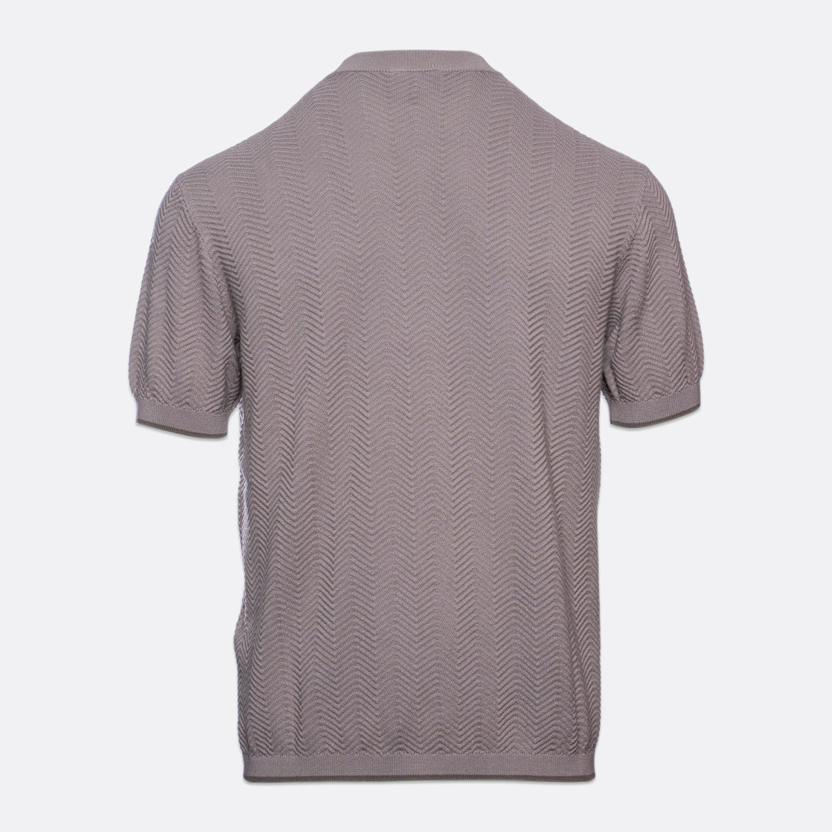 A short-sleeve knit polo shirt shown from the back, featuring a textured chevron pattern in a muted taupe-gray color, set against a plain light gray background. Emporio Armani T-Shirt. Sakks Menswear Southampton.