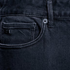 Close-up of the back pocket and waistband of dark washed denim jeans, showing a silver metal button and a small black brand tab. Emporio Armani Jeans. Sakks Menswear Southampton.